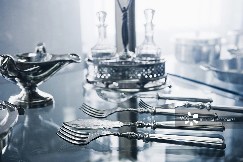 玻璃桌上的旧银器图片素材