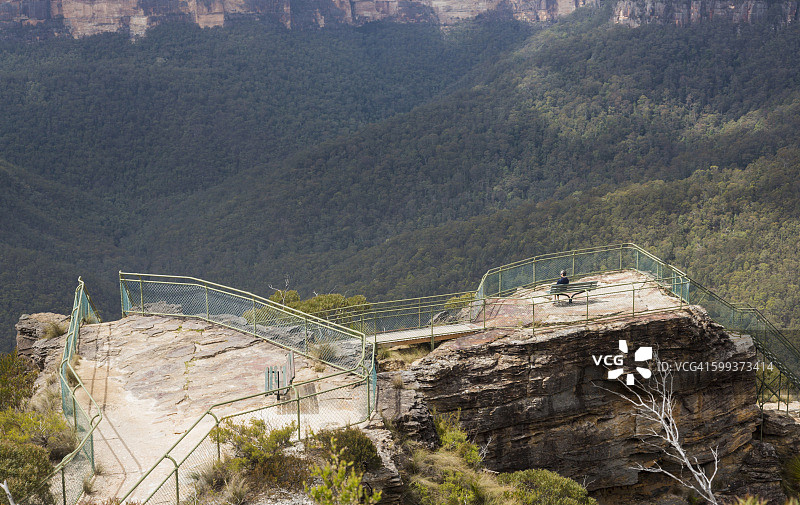 坐在长椅上眺望格罗斯山谷和蓝山国家公园的徒步女性，新南威尔士州，澳大利亚图片素材
