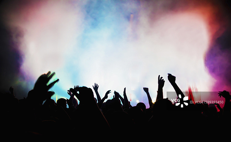 在夜总会或摇滚音乐会上举手欢呼的人们图片素材