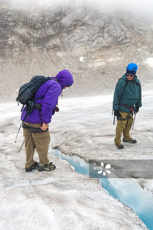两位年长的白人凝视着冰隙图片素材