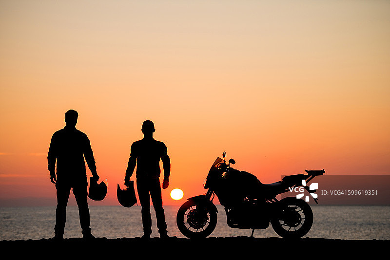 日出时在海滩上的摩托车骑手图片素材