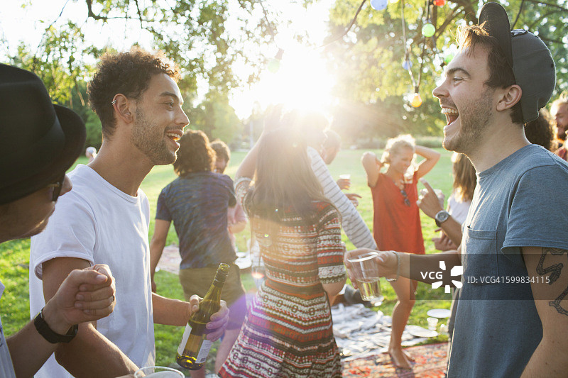 日落时分在公园聚会聊天的成年朋友们图片素材