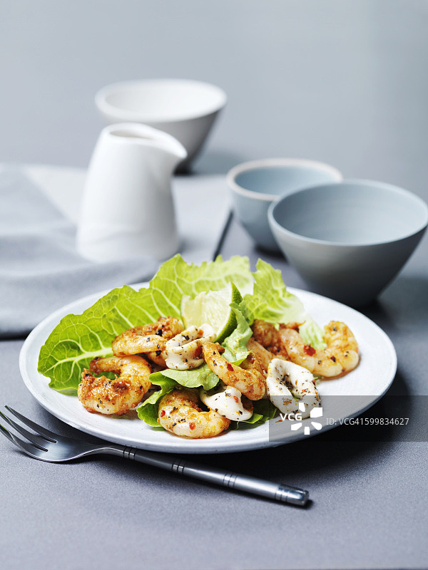 唐杜里烤虾和炭烤鱿鱼配青柠片和生菜图片素材