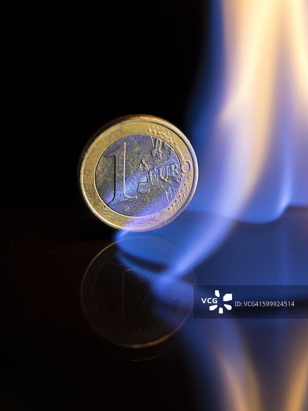 危机之火焚烧下的欧元硬币图片素材