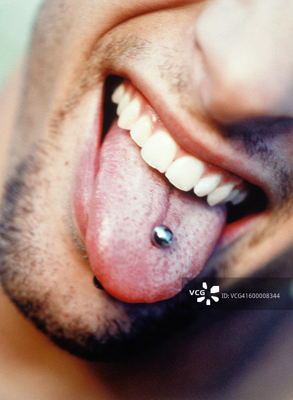 年轻人伸出穿孔的舌头图片素材