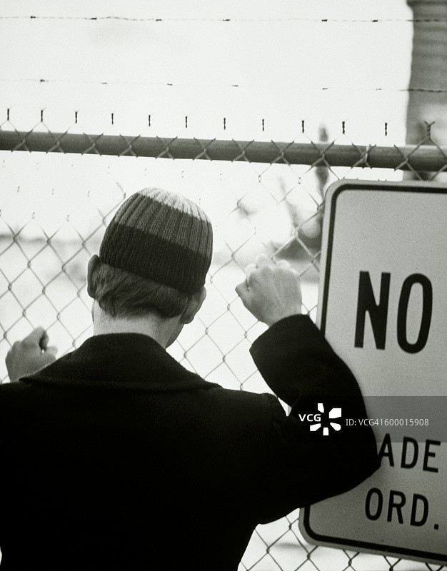 站在栅栏前的男人图片素材