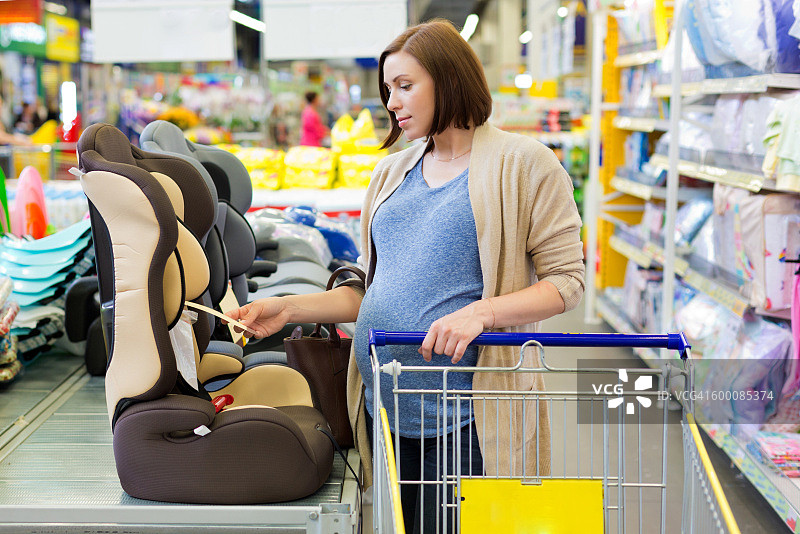 孕妇在商店购买汽车婴儿座椅图片素材
