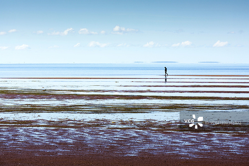 在海滩上行走的男子图片素材