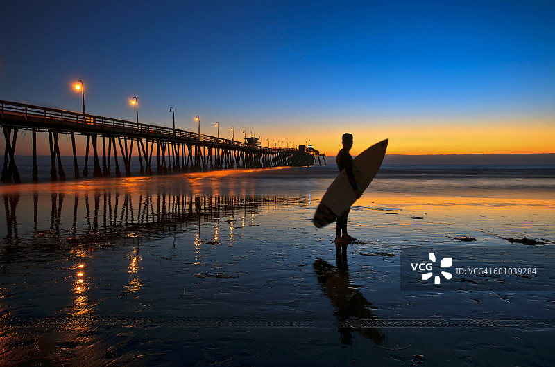 帝国海滩码头的冲浪者剪影图片素材