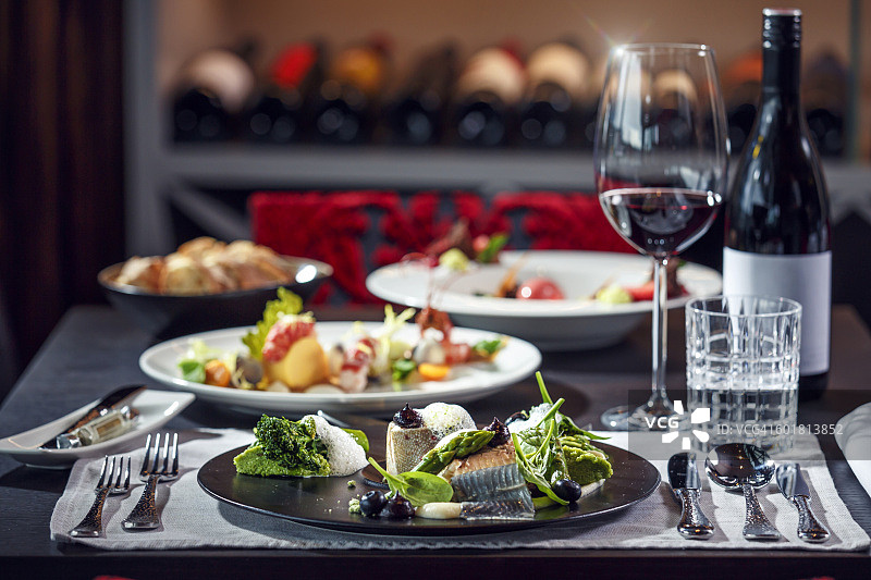 美味晚餐：精致的鱼肉搭配绿色蔬菜图片素材