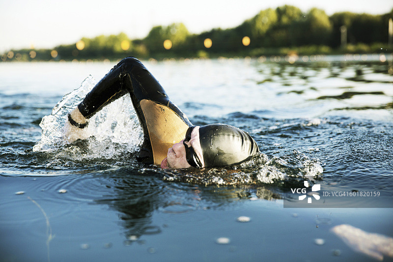 在湖中游泳的铁人三项运动员图片素材