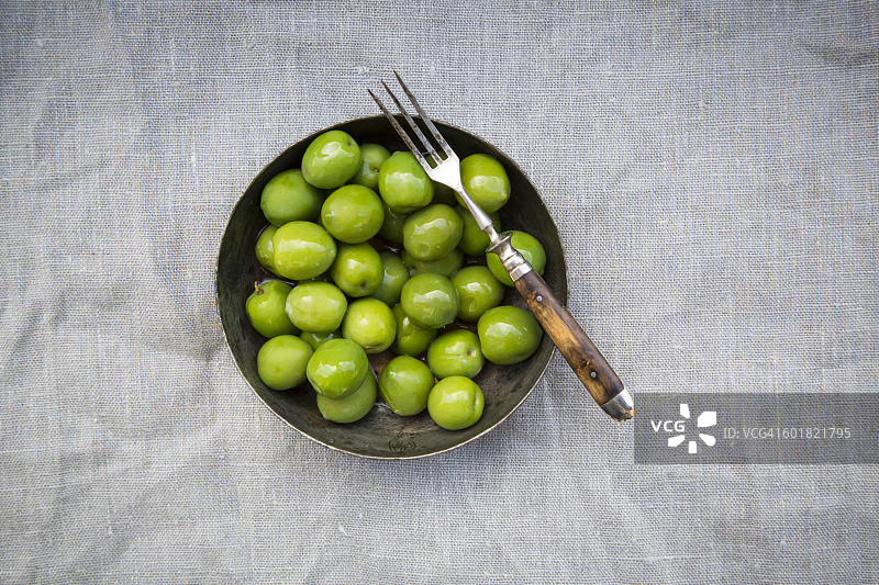 碗中绿橄榄和叉子图片素材