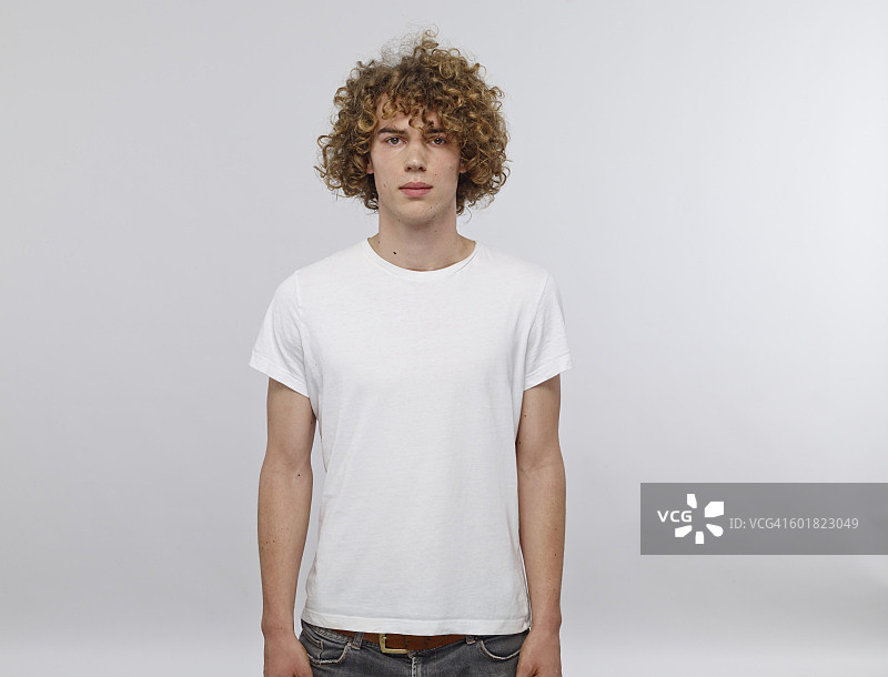 穿着白色T恤的金色卷发年轻男子肖像图片素材