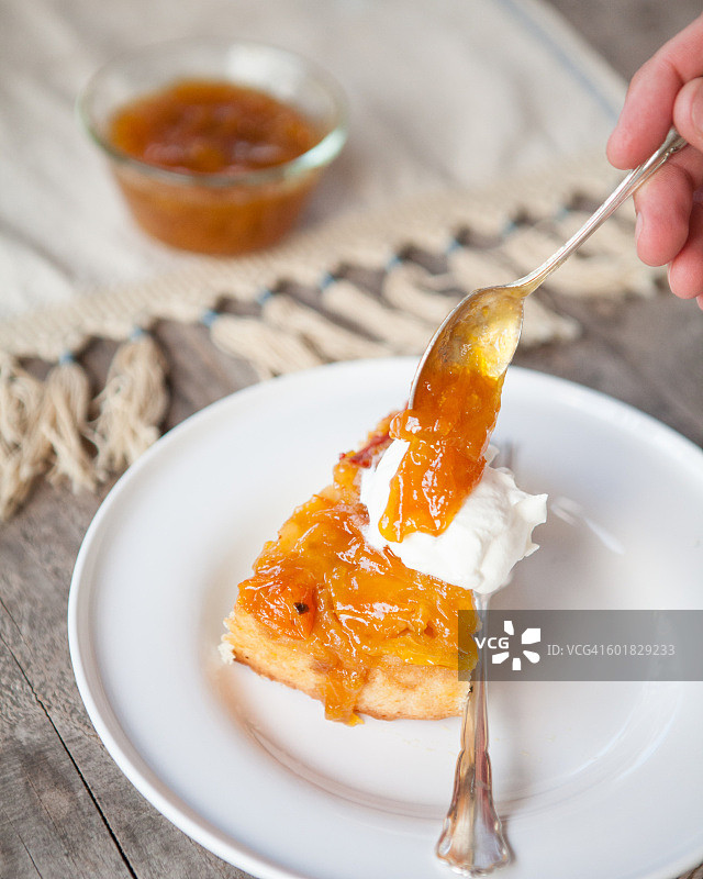 用勺子在倒扣的蛋糕和奶油上浇汁图片素材