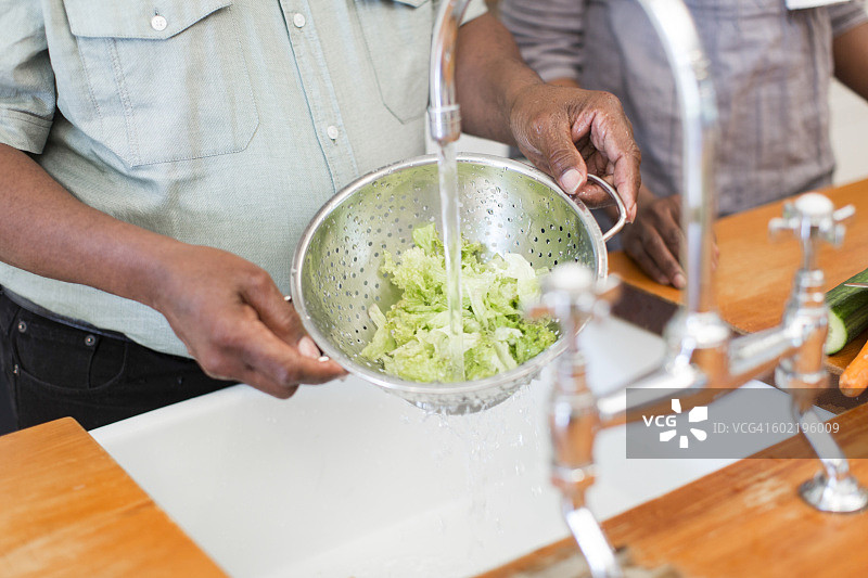 南非开普敦：老年男人清洗沙拉图片素材