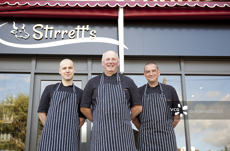 三名男屠夫在肉店外的肖像图片素材