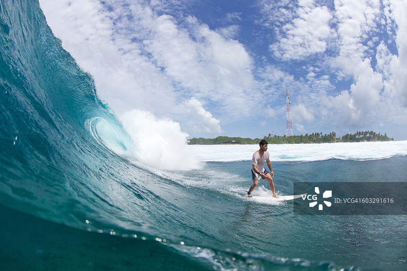 在热带地区美丽蓝色海浪上的冲浪者图片素材