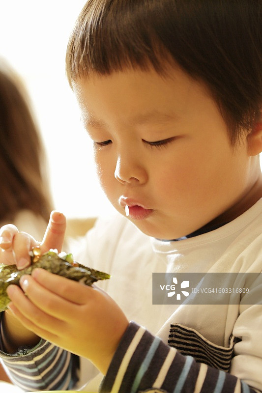 小男孩制作手卷寿司特写图片素材