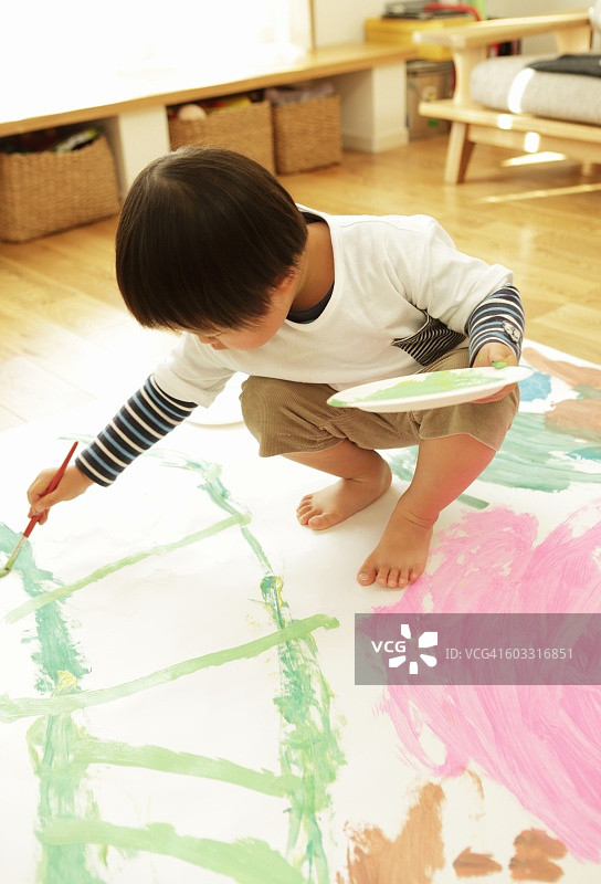 小男孩在房间里画画图片素材
