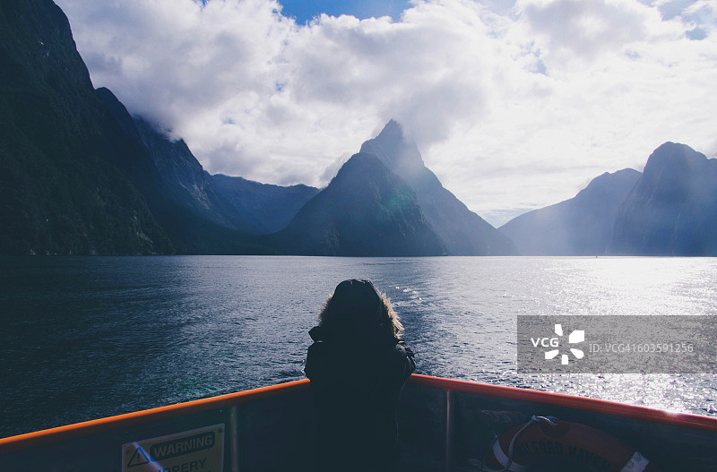 孩子在船上拍摄米特峰，位于米尔福德峡湾图片素材