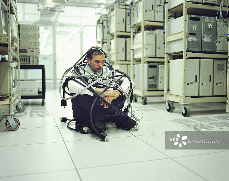 男人被电脑线缠住图片素材