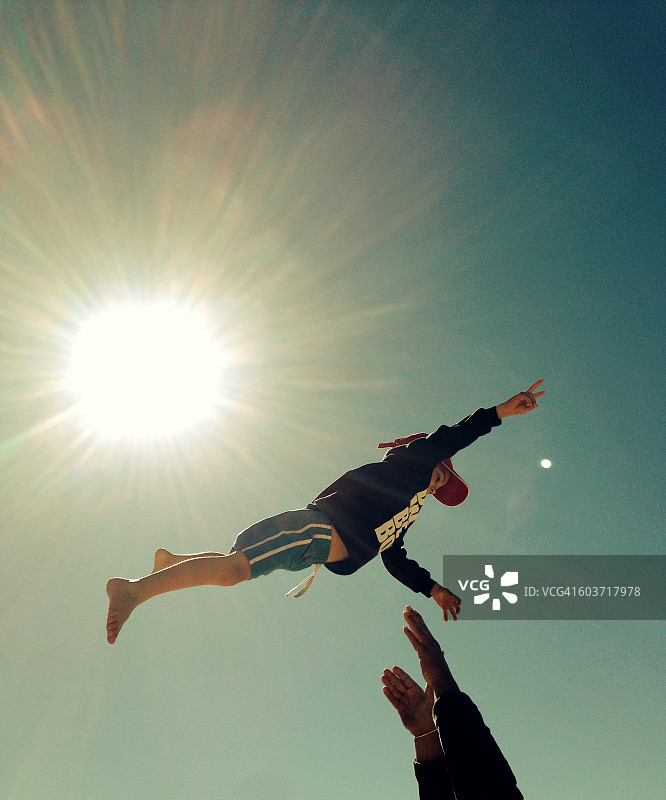 在空中做出和平手势的男孩图片素材