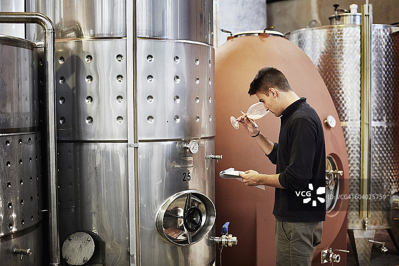 男人拿着写字板闻葡萄酒图片素材