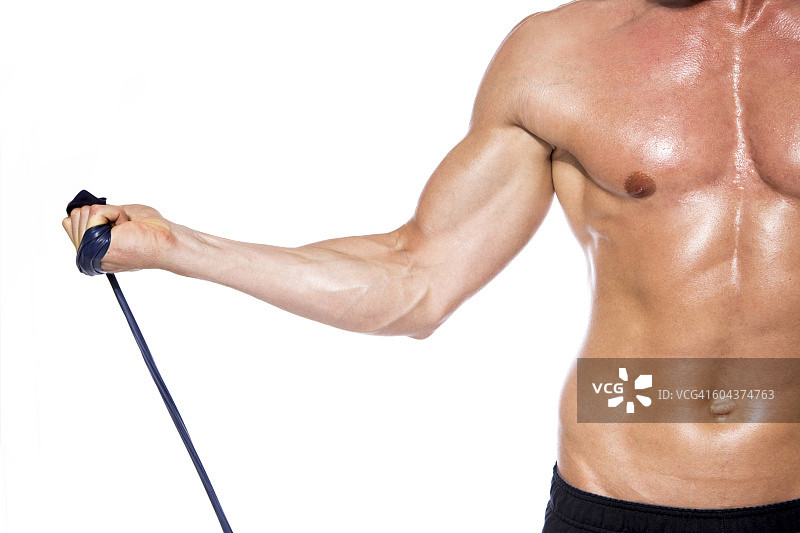 没穿上衣的健壮男人在白色背景前用健身带训练，特写图片素材