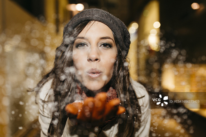 西班牙雷乌斯夜晚吹雪的年轻女人图片素材