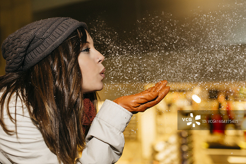 年轻女人夜晚吹雪图片素材