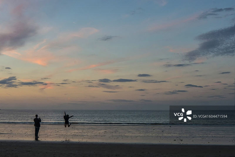 日落时分沙滩上的情侣剪影图片素材