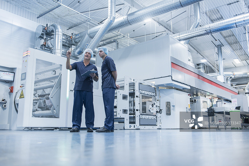 工人在食品包装印刷厂使用印刷机图片素材
