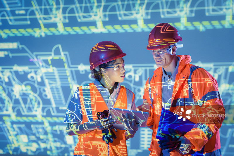 工程师使用数字平板电脑和投影图纸图片素材