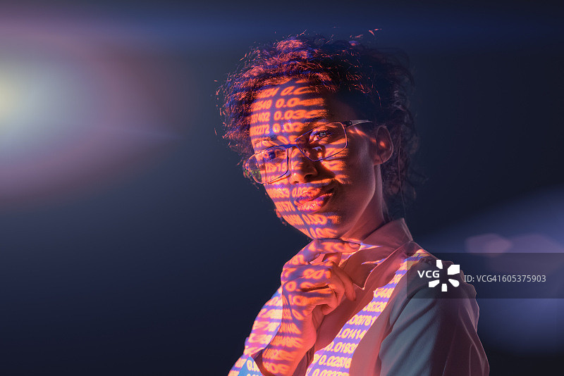 思考中的女商人，深色背景上投射出金融数字图片素材