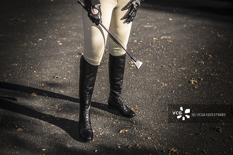 穿马靴的女人手持马鞭的下半身照图片素材