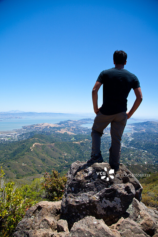 年轻男子从山顶俯瞰旧金山图片素材