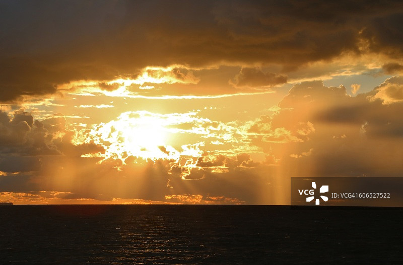 阳光穿透云层，照耀在海面上图片素材