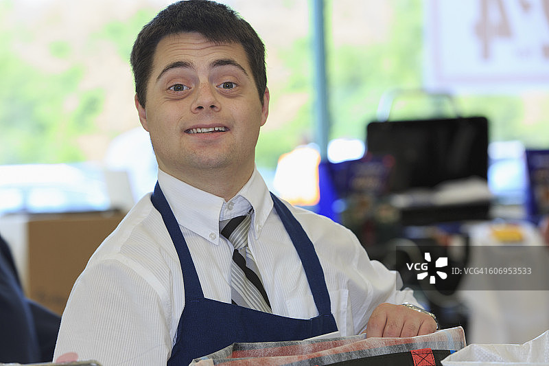 在杂货店工作的唐氏综合征男人图片素材