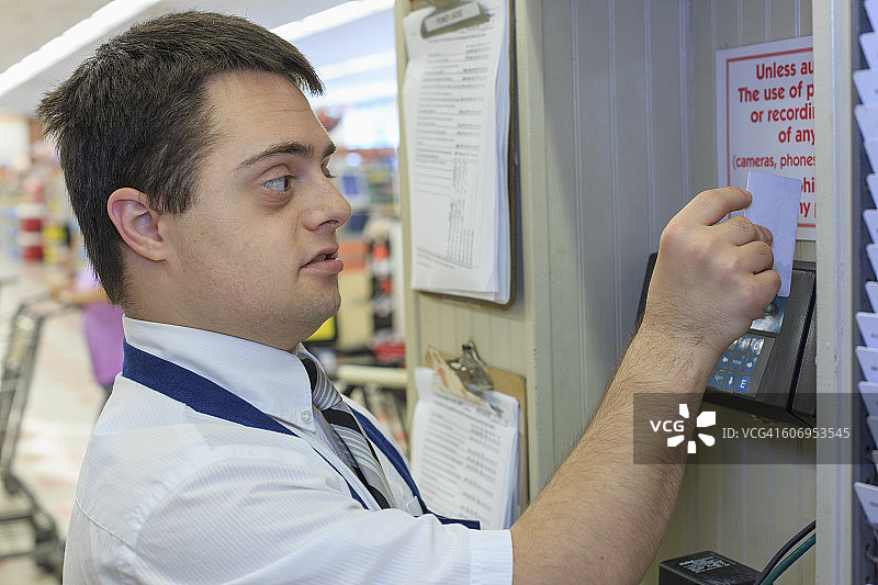 患有唐氏综合征的男子在杂货店办理入职手续图片素材