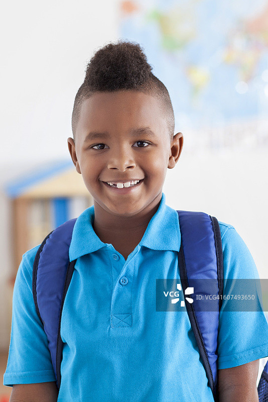 自信的男小学生在他的教室里微笑图片素材