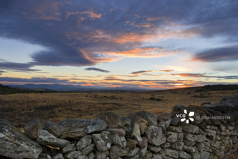 瓜达拉马山脉夏季的石栅栏和黄色草地图片素材