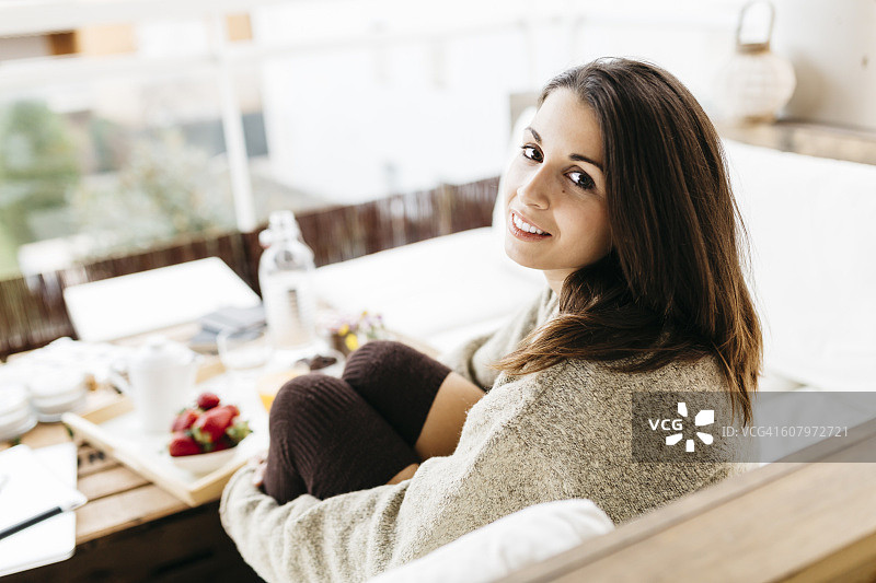 坐在阳台上微笑的女人肖像图片素材