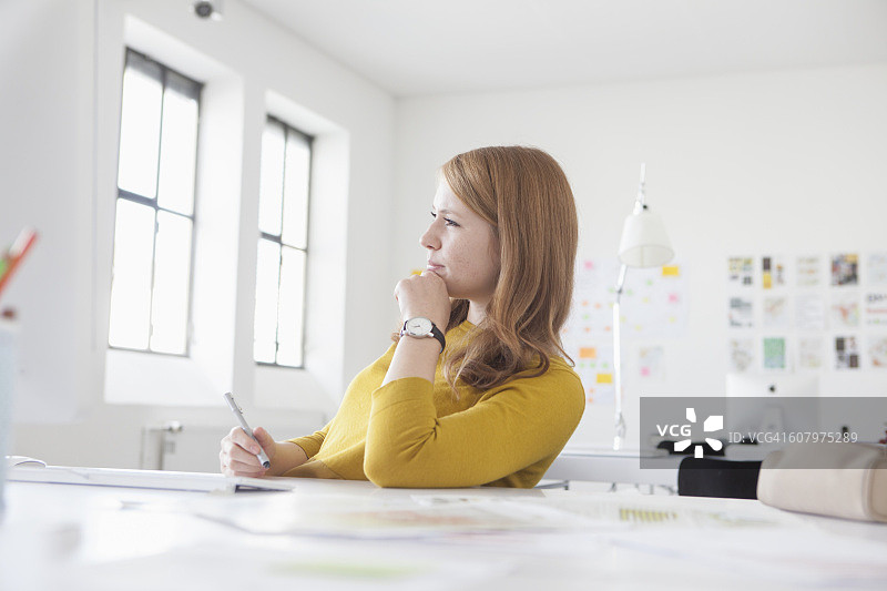 在办公室办公桌前工作的年轻女人图片素材