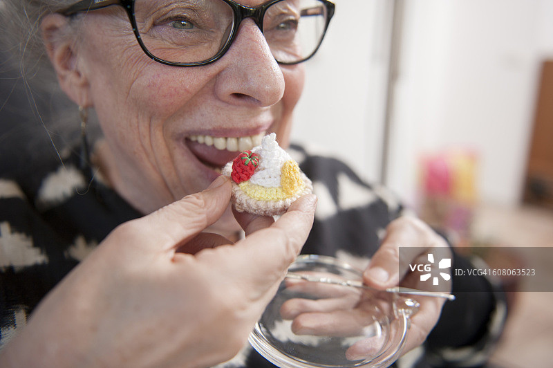 年长的女人在享用精美蛋糕图片素材