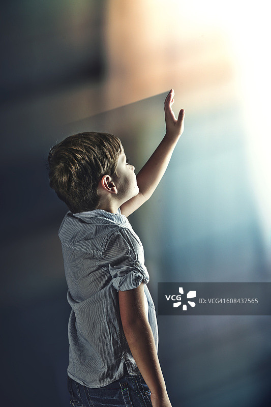 伸手触摸光芒的男孩图片素材
