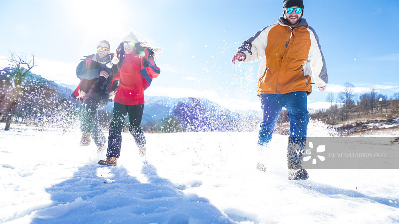 在雪地里玩耍的快乐年轻人图片素材
