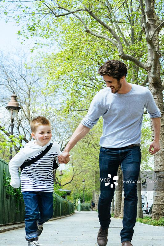 父子在公园里散步去上学图片素材