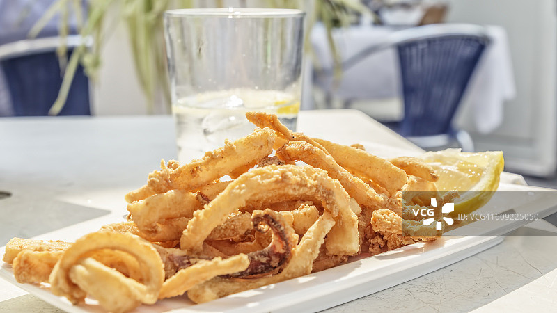 美味炸鱿鱼和一杯新鲜水图片素材