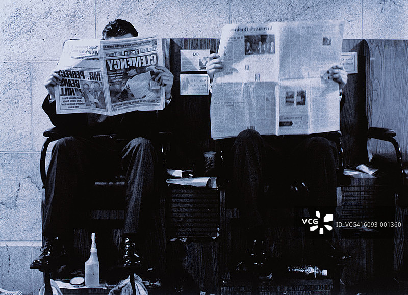 男人在擦鞋处阅读报纸图片素材