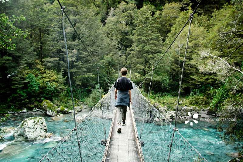 男孩穿过霍利福德河谷的吊桥图片素材